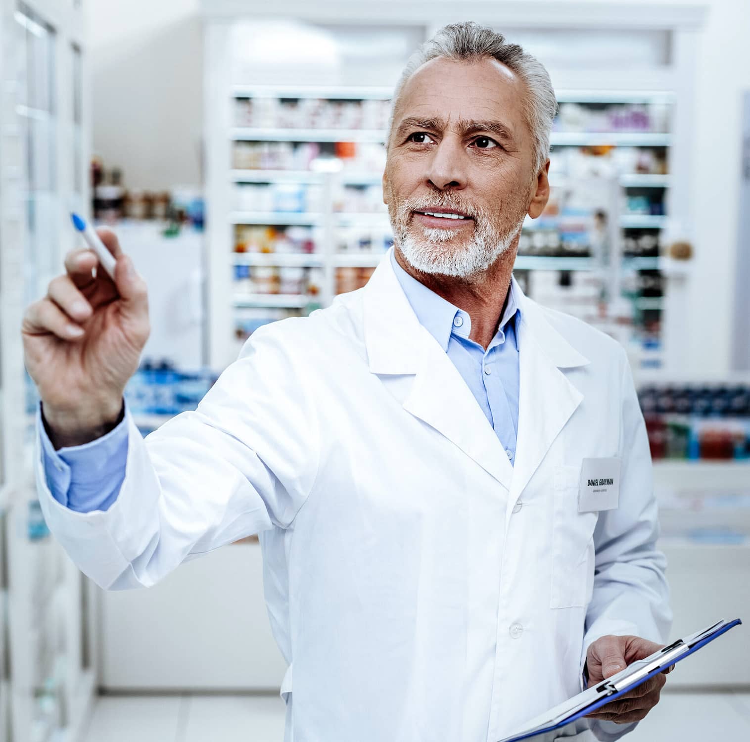 Report. Handsome bearded pharmacist in a white coat looking busy while preparing a report